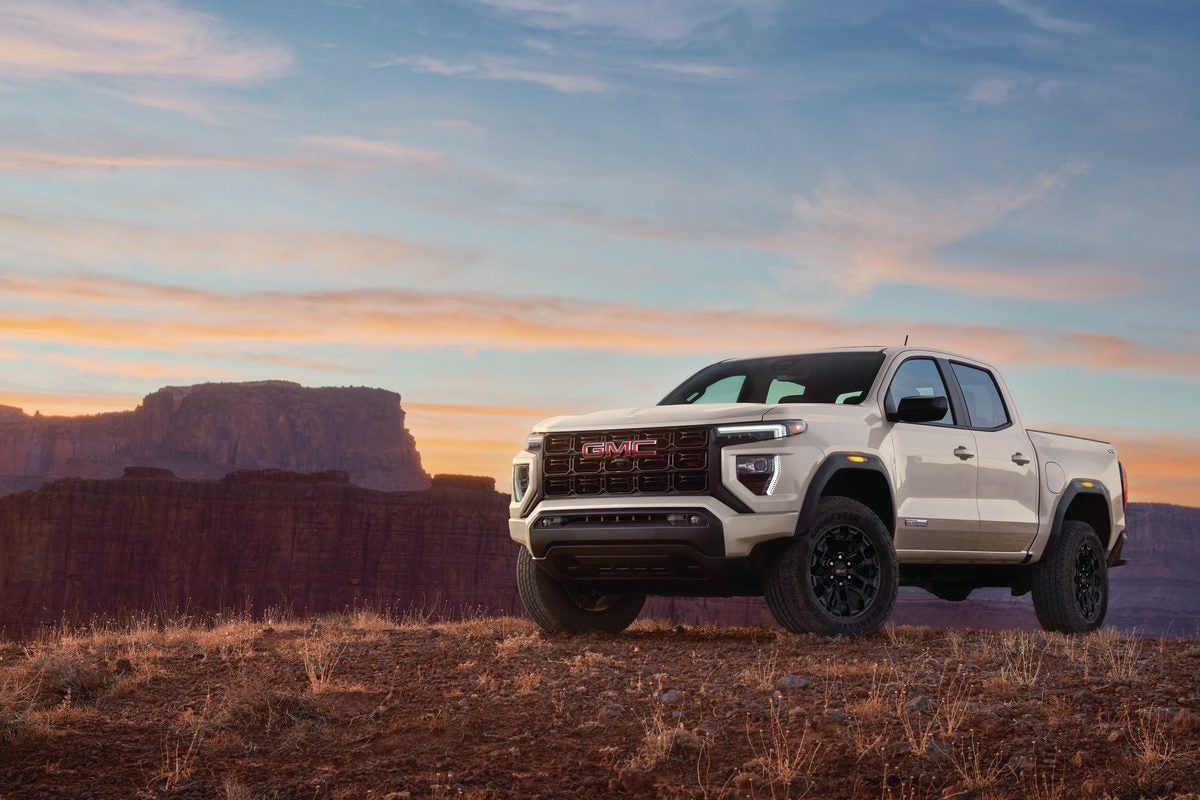 Sand-colored GMC Canyon Elevation parked above a red rock canyon at dusk