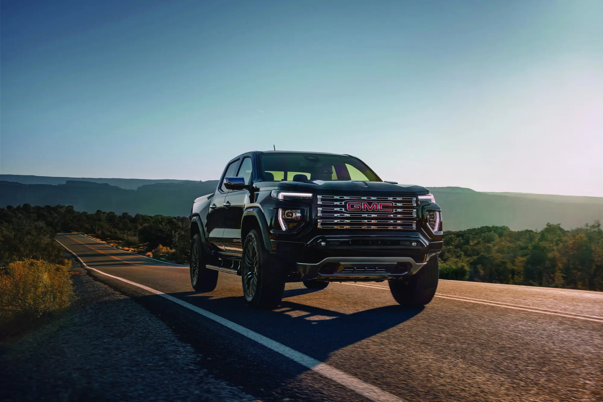 2027 GMC Canyon Denali in Onyx Black at a three-quarter front angle at dawn