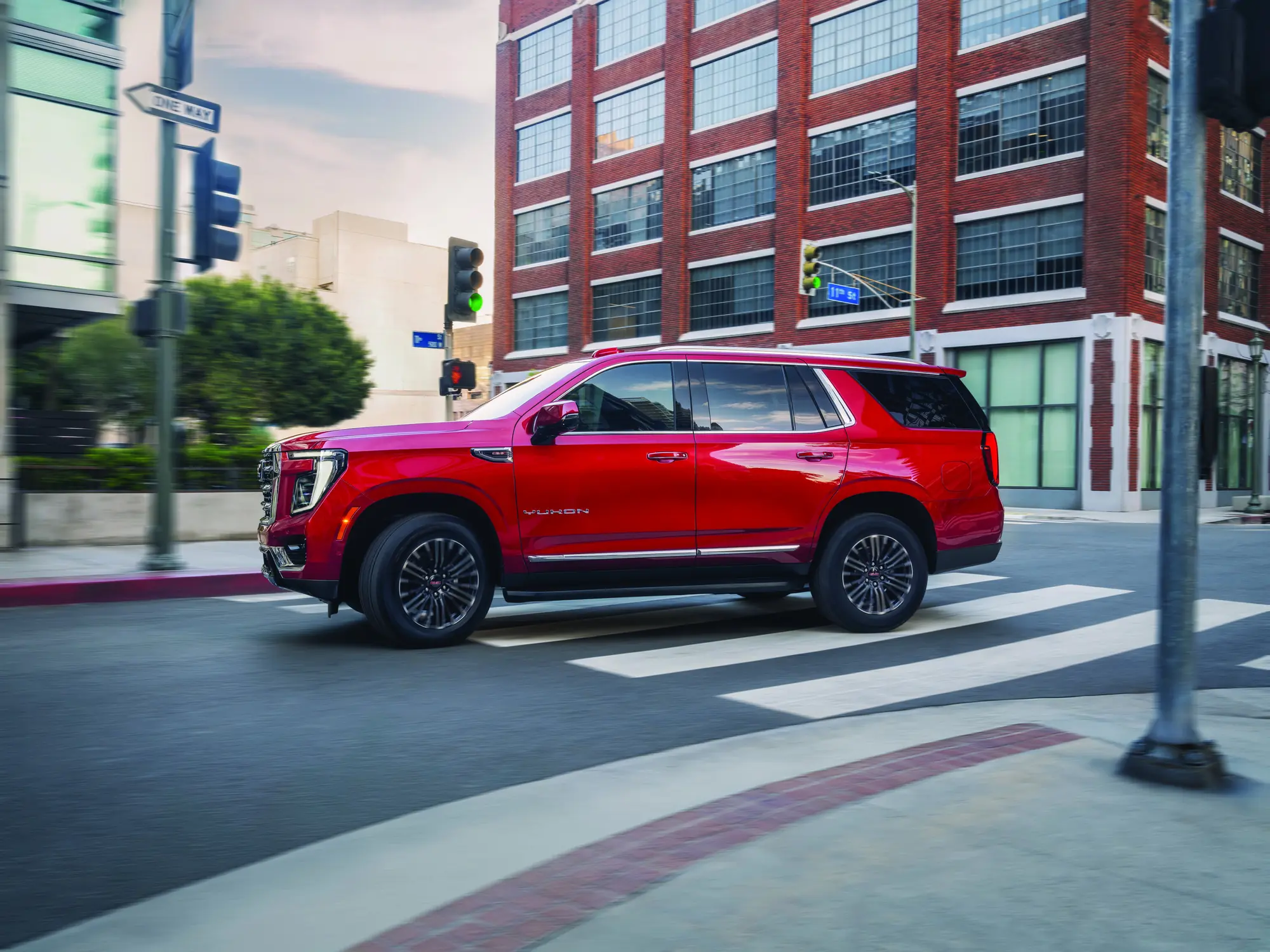 2027 GMC Yukon Elevation in Volcanic Red Tintcoat, driver side profile with side step