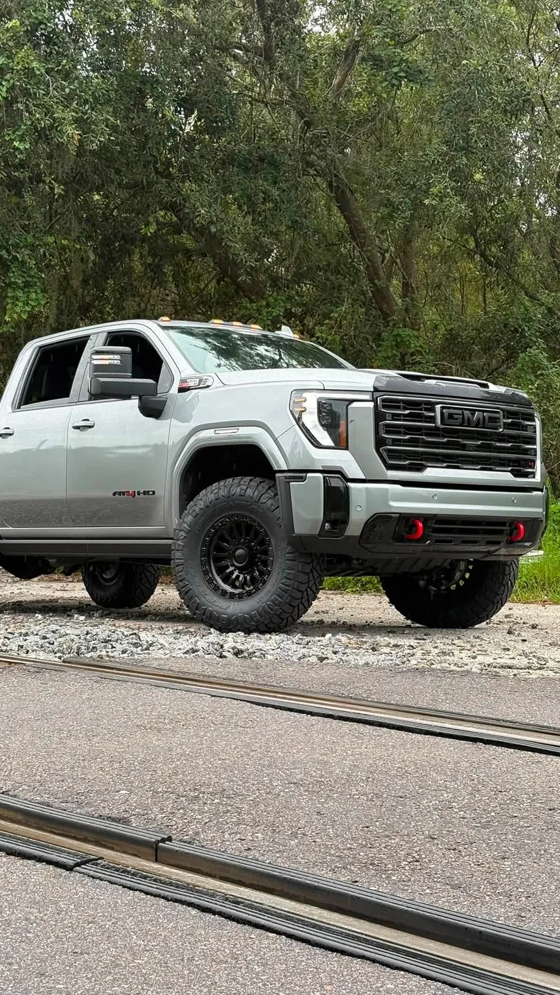 Lifted tan GMC Sierra 2500 HD AT4 on black wheels