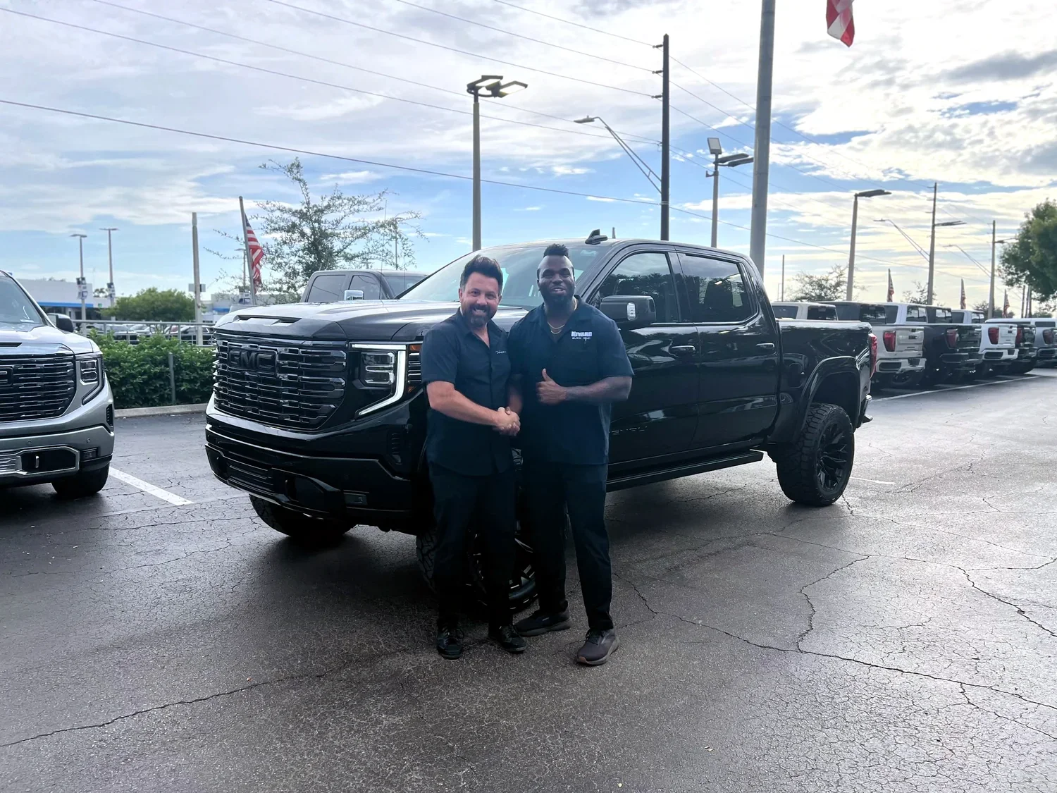Andrew shaking hands with Mr. Supreme T in front of his custom blacked out Sierra Denali build