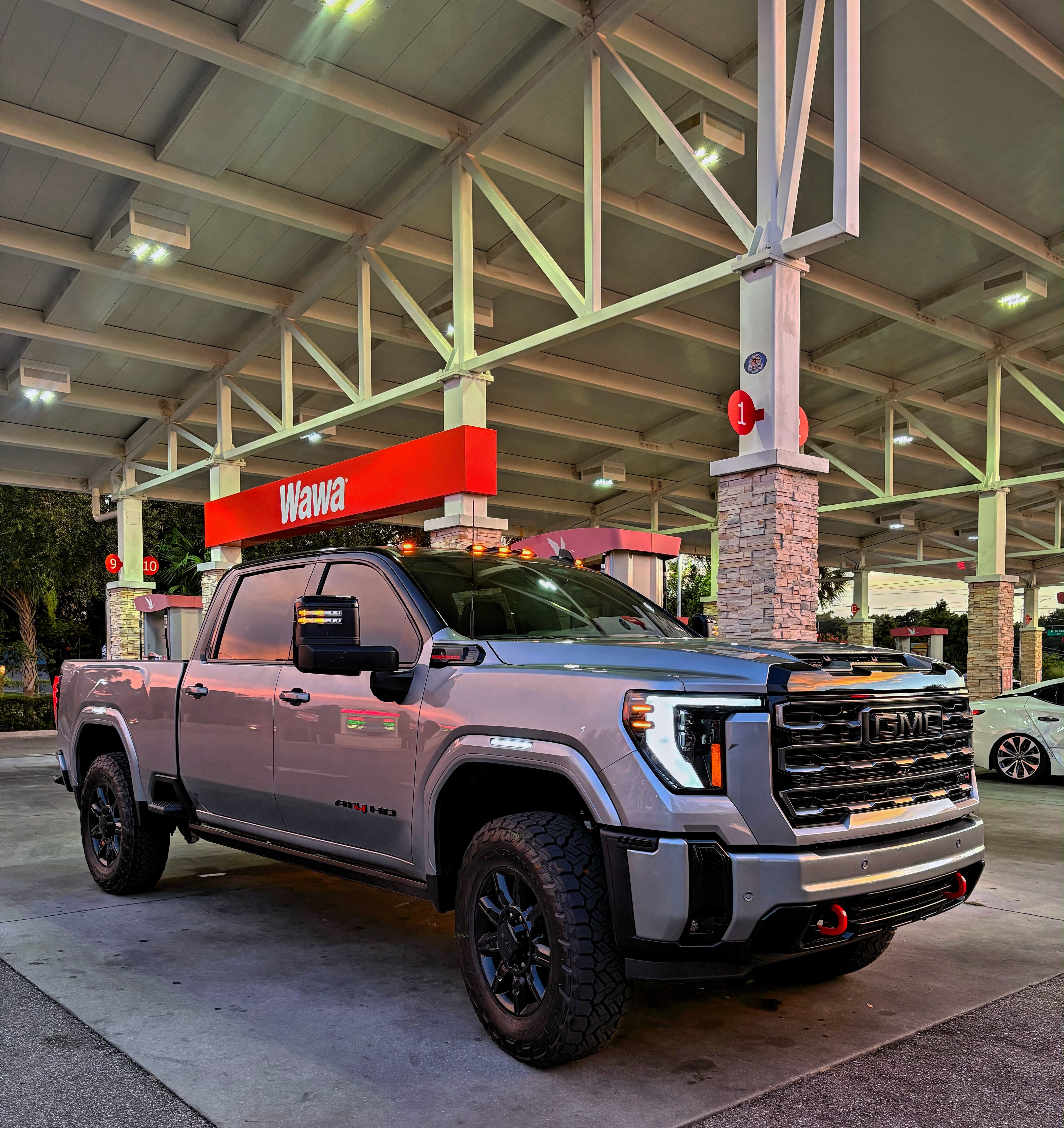 Lifted silver GMC Sierra 2500 HD AT4 at a Tampa fuel stop
