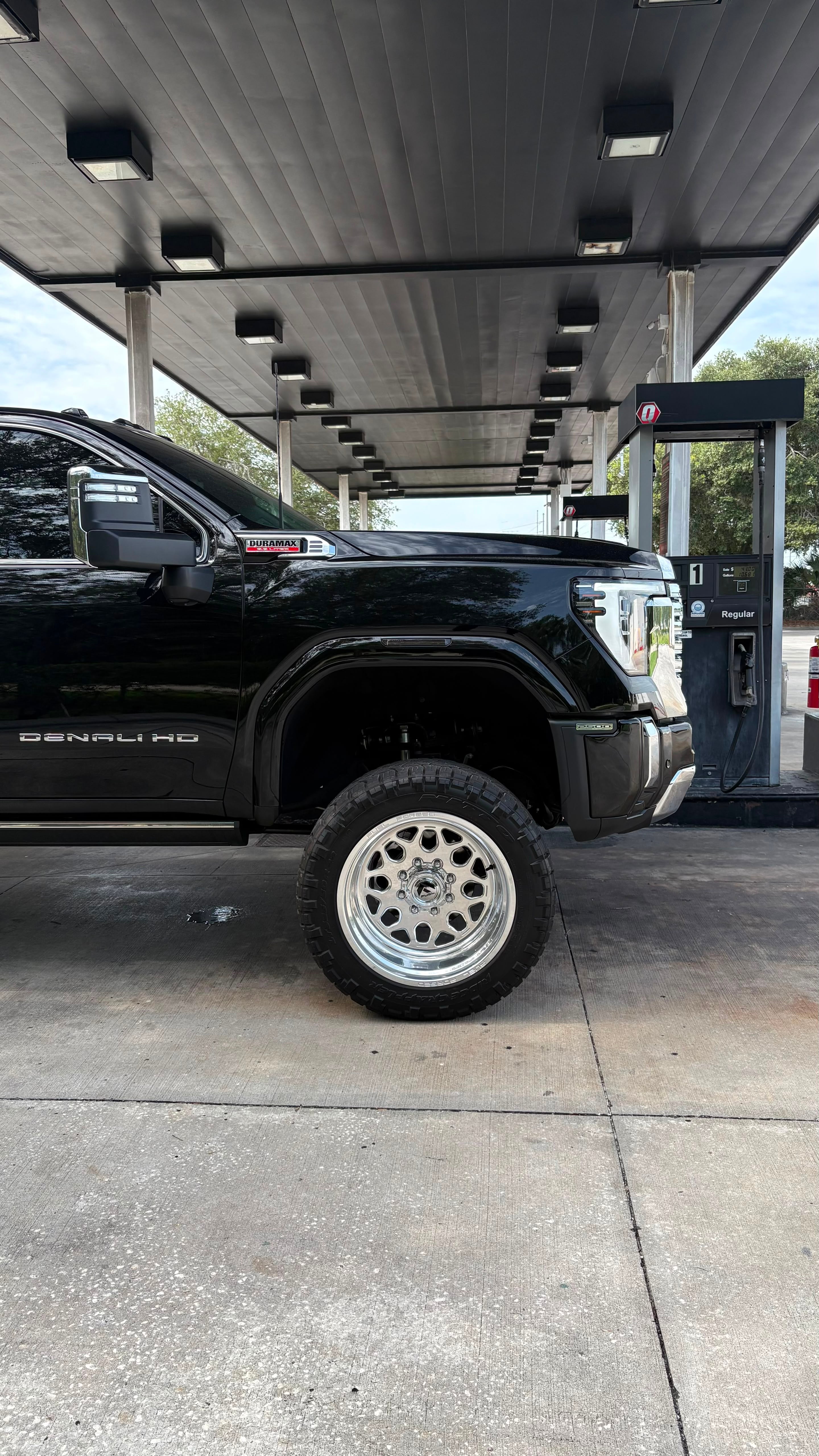 Side view of a lifted black GMC Sierra Denali HD with Duramax badging