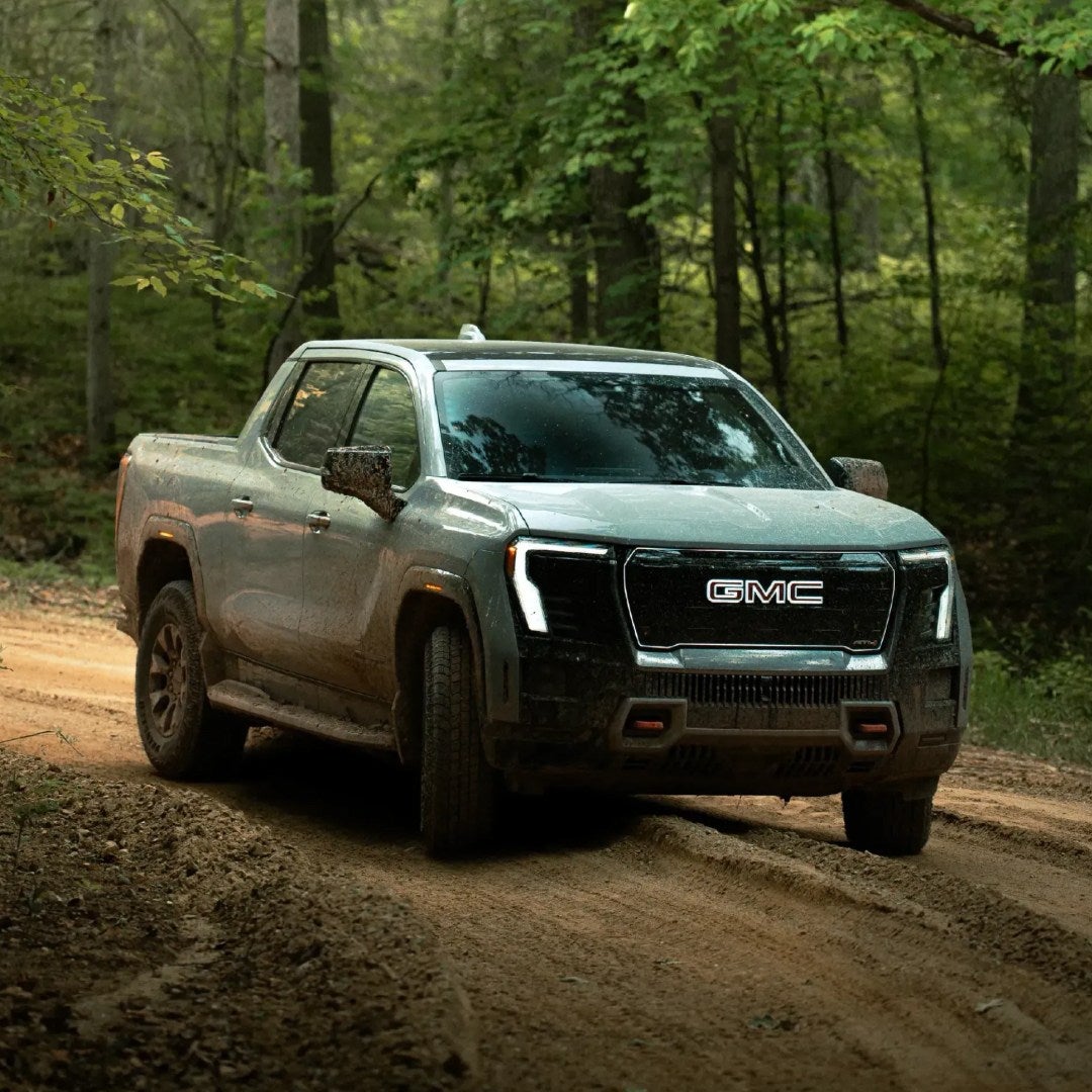 2026 GMC Sierra EV AT4 on a muddy forest trail