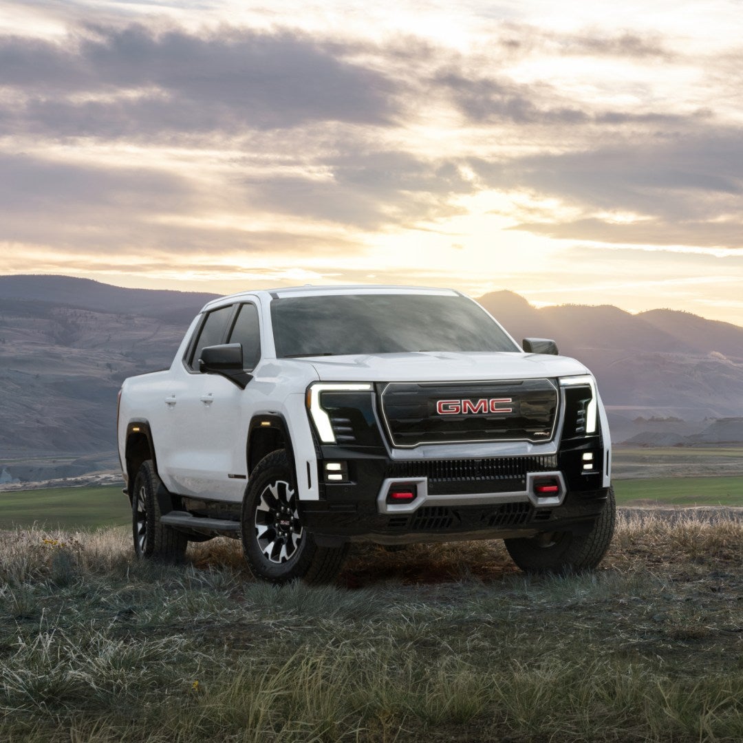2026 GMC Sierra EV AT4 parked in an open field at sunset