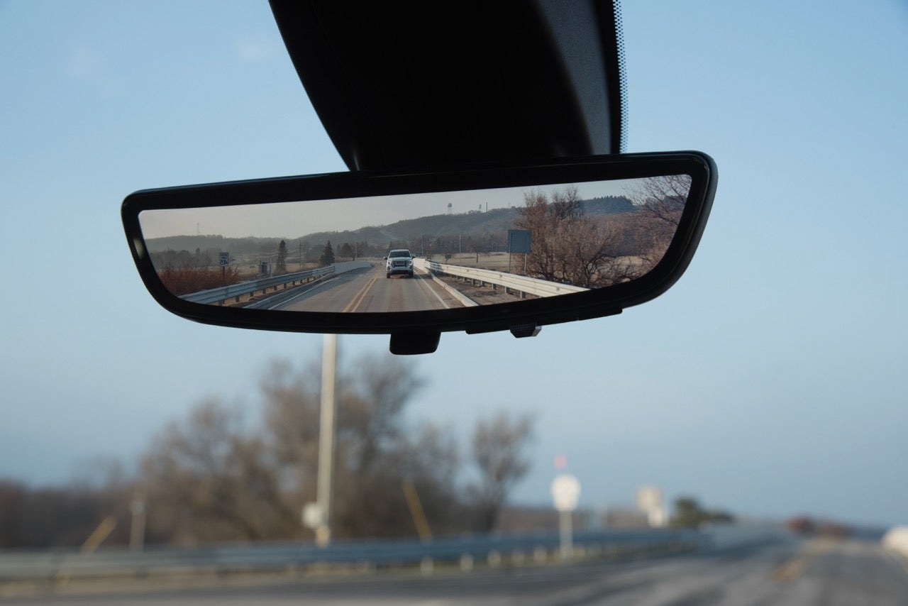 2027 GMC Sierra HD Rear Camera Mirror showing the road behind